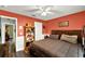 Bedroom with ceiling fan, wood floors, decorative shelving and a brown bed set at 1608 Victoria Way, Winter Garden, FL 34787