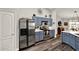 Well-lit kitchen with stainless steel appliances, blue cabinets, and hardwood floors offering a modern and convenient space at 1608 Victoria Way, Winter Garden, FL 34787