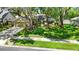 Green grassy yard with mature landscaping, and a tidy garden in front of the house at 1608 Victoria Way, Winter Garden, FL 34787