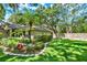 Green grassy yard featuring an island of flowers and palm trees, along with stone borders at 1608 Victoria Way, Winter Garden, FL 34787
