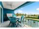 Outdoor patio with blue walls and a table and chairs overlooking a body of water and palm trees at 1 Riverwalk Dr # 303, New Smyrna Beach, FL 32169