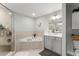 Well-lit bathroom featuring a glass shower, large soaking tub, dual vanity sinks and clean, modern finishes at 1 Riverwalk Dr # 303, New Smyrna Beach, FL 32169