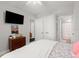 Inviting bedroom with a mounted TV, dresser, and ensuite bathroom, offering convenience and relaxation at 1 Riverwalk Dr # 303, New Smyrna Beach, FL 32169