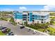 A detailed view of the building's facade, enhanced with landscaping, lush greenery, and ample parking space at 1 Riverwalk Dr # 303, New Smyrna Beach, FL 32169