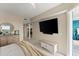 Bright bedroom featuring a dresser, TV, and balcony access with a view of the water at 1 Riverwalk Dr # 303, New Smyrna Beach, FL 32169