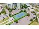 Aerial shot of the community's well-maintained tennis court surrounded by parking and lush landscaping at 1 Riverwalk Dr # 303, New Smyrna Beach, FL 32169