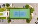 Top-down view of the tennis court, nestled among trees and parking areas, with a seating area nearby at 1 Riverwalk Dr # 303, New Smyrna Beach, FL 32169