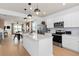 Open floor plan view from the kitchen of living and dining rooms with wood floors at 10154 Hadley St, Orlando, FL 32829