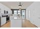 Bright kitchen with white cabinets, stainless steel appliances, and a quartz island at 10154 Hadley St, Orlando, FL 32829