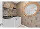 A laundry room with wallpaper, shelves and a Whirlpool washer and dryer at 10154 Hadley St, Orlando, FL 32829
