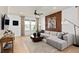 Stylish living room with a large sectional sofa, unique wall decor, and a ceiling fan for added comfort at 10154 Hadley St, Orlando, FL 32829