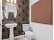 Stylish powder room with a pedestal sink, toilet, and accent wall at 10154 Hadley St, Orlando, FL 32829