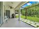 View of the covered patio with ceiling fan, grill, and an outdoor space with walkway to the large grassy backyard at 10252 Kristen Park Dr, Orlando, FL 32832