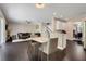 An open-concept living room with dark floors and neutral paint is connected to a dining area and a bar-style kitchen at 10252 Kristen Park Dr, Orlando, FL 32832