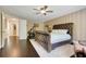 Spacious primary bedroom with a padded headboard, wood floors, and a ceiling fan at 10252 Kristen Park Dr, Orlando, FL 32832
