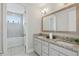 Bright bathroom featuring double vanity with granite countertop and a separate tub with tiled surround at 108 Stanton Estates Cir, Winter Garden, FL 34787