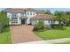 Beautiful two-story home featuring a brick driveway, lush landscaping, and a neutral color scheme at 108 Stanton Estates Cir, Winter Garden, FL 34787