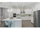 Modern kitchen with white cabinets, stainless steel appliances, and an island with bar seating at 108 Stanton Estates Cir, Winter Garden, FL 34787