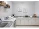 Well-lit laundry room with modern appliances, granite countertops, and ample storage space at 108 Stanton Estates Cir, Winter Garden, FL 34787