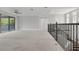 Spacious loft with carpet flooring, iron railings, and ample natural light, perfect for relaxation at 108 Stanton Estates Cir, Winter Garden, FL 34787