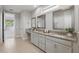 Bright main bathroom featuring a double vanity with granite countertops and frameless glass shower at 108 Stanton Estates Cir, Winter Garden, FL 34787