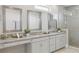 A sleek main bathroom featuring a double vanity with granite countertops and a glass-enclosed shower at 108 Stanton Estates Cir, Winter Garden, FL 34787