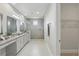 A well-lit main bathroom with double vanity, granite counters, and a frameless glass shower at 108 Stanton Estates Cir, Winter Garden, FL 34787
