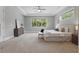 Bright main bedroom with neutral tones, large windows with tree views, and carpet flooring at 108 Stanton Estates Cir, Winter Garden, FL 34787