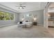 Spacious main bedroom with tray ceiling, ceiling fan, and large windows with a view to the yard at 108 Stanton Estates Cir, Winter Garden, FL 34787