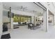 Covered outdoor patio featuring a ceiling fan, outdoor kitchen, and an entertainment area at 108 Stanton Estates Cir, Winter Garden, FL 34787