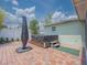 Backyard patio area with a covered hot tub, umbrella and brick flooring at 12020 Philbrook Ct, Orlando, FL 32825