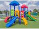 Colorful playground with slides and climbing structures on a green artificial turf surface at 12020 Philbrook Ct, Orlando, FL 32825