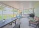 Screened porch featuring a picnic table and couch, perfect for outdoor relaxation at 12020 Philbrook Ct, Orlando, FL 32825