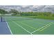 Outdoor tennis court enclosed by chain-link fencing, featuring green and blue playing surface at 12020 Philbrook Ct, Orlando, FL 32825