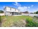 The house features a big backyard with a screen patio and a white fence at 125 Vervain Ave, Davenport, FL 33837