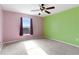 Bedroom with a mix of pink and lime-green walls, carpet, and view of neighborhood at 125 Vervain Ave, Davenport, FL 33837