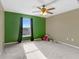 Spacious bedroom features green accent wall, neutral carpets and a large window offering ample natural light at 125 Vervain Ave, Davenport, FL 33837