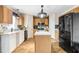 Kitchen with wood cabinets, white countertops, island, and black appliances creating a functional space at 125 Vervain Ave, Davenport, FL 33837