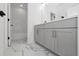 Modern bathroom showcasing marble floors, gray vanity cabinets, sleek hardware and a bright, clean design at 13081 Sunrise Harvest Dr, Winter Garden, FL 34787