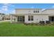 Landscaped backyard featuring a manicured lawn, covered patio, and modern building exterior, ideal for outdoor enjoyment at 13175 Telsen St # 40, Winter Garden, FL 34787