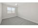 An airy bedroom featuring gray carpet, a ceiling fan and a window looking out to the neighborhood at 13175 Telsen St # 40, Winter Garden, FL 34787