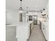 Bright, white kitchen features a large island with waterfall countertops and pendant lighting at 13175 Telsen St # 40, Winter Garden, FL 34787