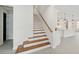 Staircase with wood treads and white risers leading to the upper level, with natural light at 13175 Telsen St # 40, Winter Garden, FL 34787