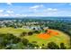 Aerial shot showcasing a well-maintained baseball field, lake, and residential area in a lush, green environment at 1390 Yellow Pine Ct, Winter Springs, FL 32708