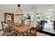 Dining area featuring a wooden table, chandelier, and an open view of the modern kitchen at 1390 Yellow Pine Ct, Winter Springs, FL 32708