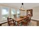 Dining area featuring a wooden table, chandelier, and ample natural light from nearby windows at 1390 Yellow Pine Ct, Winter Springs, FL 32708