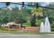 Elegant entrance to Tuscawilla Country Club, featuring a tiered water fountain and lush landscaping at 1390 Yellow Pine Ct, Winter Springs, FL 32708