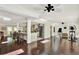Large living area features hardwood floors, a ceiling fan, and access to the kitchen and fitness area at 1390 Yellow Pine Ct, Winter Springs, FL 32708