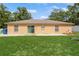 Spacious backyard featuring a sliding glass door, privacy fence, and well-maintained lawn at 1395 Deland Ave, Orange City, FL 32763