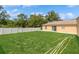 Expansive backyard featuring lush grass, a shed, and a secure privacy fence, perfect for outdoor activities at 1395 Deland Ave, Orange City, FL 32763